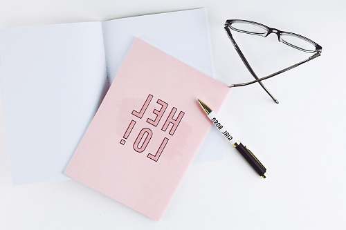 pen black ballpoint pen beside pink paper with hello written united states